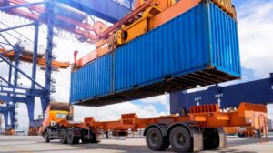 UIIA with a truck's trailer being loaded with a shipping container